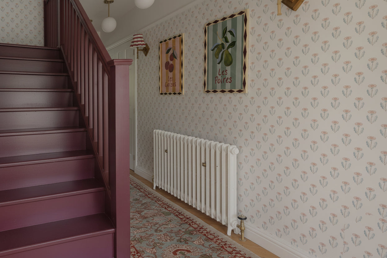 Staircase with pink railings and a decorative rug in a home interior.